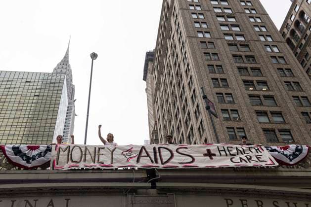 June 26, 2026, New York, New York, USA: Members of ACT UP New York begin Pride weekend with an act of civil disobedience blockading traffic during the morning rush hour on 42nd Street outside Grand Central Station stating solidarity with striking Delaney Hall immigrant detainees and denouncing Trump administration cuts to AIDS funding and healthcare. After traffic is at a standstill for approximately 40 minutes, NYPD arrests demonstrators. The protest banner is Ã¢â‚¬ËœMoney for AIDS and Healthcare Not for ICE and Warfare. Demonstrators defend New YorkÃ¢â‚¬â ¢s sanctuary city status as an ICE surge is promised and protest funding cuts to AIDS Drug Assistance Programs (ADAP,) The U.S. PresidentÃ¢â‚¬â ¢s Emergency Plan for AIDS Relief (PEPFAR  - ZUMAr174 20260626_znp_r174_008 Copyright: xGinaxMxRandazzox