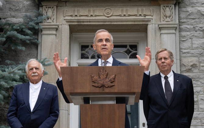 June 26, 2026, Ottawa, On, Canada: Moshe Safdie, left, and Rideau Hall Foundation CEO Rob Prichard look on as Prime Minister Mark Carney speaks at an event outside of the official residence of the Prime Minister of Canada at 24 Sussex Dr., in Ottawa, Friday, June 26, 2026. Ottawa Canada  - ZUMAc35_ 20260626_zaf_c35_015 Copyright: xAdrianxWyldx