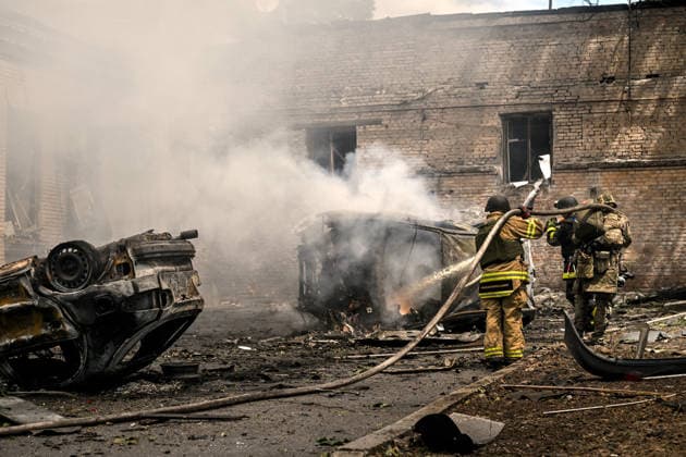 Rescuers from the State Emergency Service pour water onto a burning car that caught fire due to a Russian attack, Zaporizhzhia, Ukraine, June 26, 2026. In the afternoon, Russian forces launched two ballistic missiles at the city centre. The attack partially destroyed a one-storey office building, damaged warehouses, shattered windows and damaged the facades and roofs of nearby residential buildings, and set four cars on fire. At least 15 people were injured, including a nine-year-old child. (Photo by Dmytro Smolienko Ukrinform) Russian occupiers attack Zaporizhzhia with ballistic missiles  Copyright: xDmytroxSmolienkox