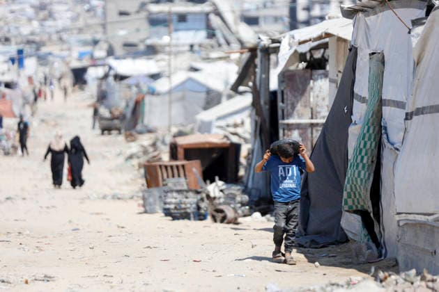 Jabalia Gaza Daily Life Palestinian residents walk along a road lined with makeshift shelters and rubble in Jabalia, northern Gaza Strip on June 27, 2026. Residents remain among the ruins of damaged and destroyed buildings in Jabalia, where access to basic services such as water, electricity, and shelter remains severely limited. Gaza Gaza Strip Palestinian Territories Copyright: xAhmedxAlxArinix