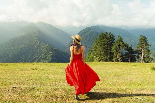 Elegante hübsche Frau in rotem Kleid spaziert auf grünen Wiesen und hohen Bergen Elegant pretty woman wear red dress walk on green meadow high mountains Copyright: imageBROKER EvaldasxMikoliunas ibxemi18169954.jpg ,model released, Symbolfoto ,property released