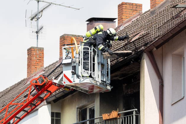 Wohnungsbrand in Mehrfamilienhaus in der Sebalder Altstadt - Spitzberg, Nürnberg, 28.06.2026 Feuerwehreinsatz an einem Mehrfamilienhaus nach einem Brand. Zwei Einsatzkräfte öffnen vom Korb einer Drehleiter aus das Dach, um an den Brandherd zu gelangen. Sichtbare Brandschäden an Fassade und Dachbereich. Einsatz bei extremer Sommerhitze von 36Â°C. *** Apartment fire in a multi-family building in the Sebald Old Town of Spitzberg, Nuremberg, June 28, 2026 Fire department response to a fire in an apartment building Two firefighters open the roof from the basket of a turntable ladder to reach the source of the fire Visible fire damage to the facade and roof area Operation conducted amid extreme summer heat of 36°C 20260628-1V9A4630-M4000