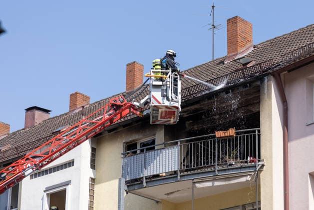 Wohnungsbrand in Mehrfamilienhaus in der Sebalder Altstadt - Spitzberg, Nürnberg, 28.06.2026 Ein Feuerwehrmann löscht von einer Drehleiter aus einen Brand an einem Mehrfamilienhaus. Die Fassade und der Dachbereich sind stark verrußt und beschädigt. Der Einsatz findet bei extremer Sommerhitze von rund 36Â°C statt. *** Apartment Fire in an Apartment Building in the Sebald Old Town of Spitzberg, Nuremberg, June 28, 2026 A firefighter extinguishes a fire at an apartment building from a turntable ladder. The facade and roof area are heavily soot-stained and damaged. The operation takes place amid extreme summer heat of around 36°C. 20260628-286A0527-M4000