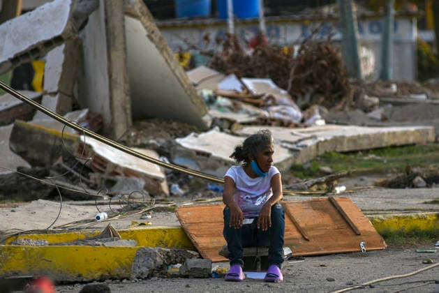 A Venezuelan woman sit beside destroyed buildings, as rescue teams continue searching for victims amid debris of a demolished building after a magnitude 7.2 earthquake struck Venezuela and other regions in the Caribbean in La Guaira, Venezuela, on June 27, 2026. According to the U.S. Geological Survey, a powerful 7.5?magnitude aftershock struck after the main quake. Medical and media sources reported that the death toll has risen to around 1,500, with some 3,000 others injured. A web page created to track the missing has listed nearly 50,000 people as unaccounted for.  VAN2026062815 JonathanxLanza