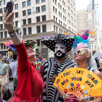 June 28, 2026, New York, New York, USA: The 57th annual NYC Pride March proceeds down Fifth Avenue from Midtown to Greenwich Village. The theme For All of Us honors the legacy of activist Marsha P. Johnson. Participants take a photo and a person holds a fan that reads DO NOT LET THEM ROB YOUR JOY. New York USA  - ZUMAr174 20260628_znp_r174_029 Copyright: xGinaxMxRandazzox