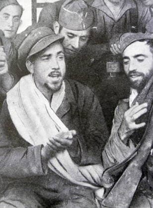 RECORD DATE NOT STATED The Spanish Civil War Black and white photograph during the Spanish Civil War (1936-1939); Antonio Ortega (1888-1939), singer and soldier, sings with his comrades during a rest in between two battles. Editorial use only. All other uses to be cleared with the copyright owner (World History Archive), in advance., WHA_134_0225.jpg, Black and white; photograph; Spanish Civil War; 1936-1939; Antonio Ortega; singer; soldier; comrades; battles; rest; historical; vintage; war; Spain; 20th century; military; music; performance; uniform; group; men; camaraderie; conflict; entertainment; downtime; solidarity; patriotism; portrait; sepia; monochrome; historic. Copyright: xWorldxHistoryxArchivex