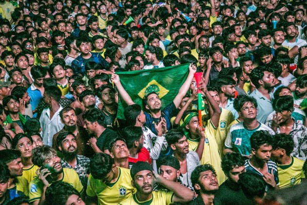 June 30, 2026, Dhaka, Munshiganj, Bangladesh: Thousands of Brazilian football supporters flood the Supermarket Chottor in Munshiganj, Bangladesh, on the night of June 29, 2026, as Brazil secured a 2-1 victory over Japan in the FIFA World Cup 2026 group stage. Despite heavy rain, the crowd Ã¢â‚¬ draped in yellow jerseys and waving green-and-gold flags Ã¢â‚¬ packed every inch of the square, climbing monument structures and rooftops to catch a glimpse of the giant screen. The atmosphere shifted from tense silence to explosive celebration as the final whistle blew, with smoke flares, fireworks, and thousands of raised hands marking one of the most electric football nights in the town s recent memory. Bangladesh has no team in the World Cu - ZUMAa259 20260630_zip_a259_001 Copyright: xRayhanxAhmedx