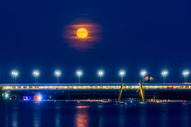 full moon on river Neue Donau (New Danube), bridge Reichsbrücke, amusement areas Copa Beach and Pier 22 Vienna 22. Donaustadt Wien Austria