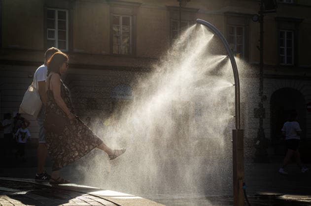 June 27, 2026, Warsaw, Mazovia, Poland: A lady stretches her leg into the spray from a cooling misting station. On the afternoon of the 28th of June, Varsovians cool and hydrate themselves around the city during a record-breaking heatwave. Due to the extreme heat, the authorities provided misting sprays and water tanks around the city. During the weekend, Warsaw experienced temperatures approaching 38Â°C as the unprecedented European heatwave swept across Poland, roughly 15Â°C above the late-June average. Tropical nights, nationwide heat alerts, and temperatures up to 40.5Â°C elsewhere in the country made this one of the most extreme heat events in modern Polish history. Warsaw Poland - ZUMAs197 20260627_aaa_s197_352 Copyright: xNeilxMiltonx