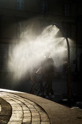 June 27, 2026, Warsaw, Mazovia, Poland: A man with his bike enjoys the relief of a cooling misting station. On the afternoon of the 28th of June, Varsovians cool and hydrate themselves around the city during a record-breaking heatwave. Due to the extreme heat, the authorities provided misting sprays and water tanks around the city. During the weekend, Warsaw experienced temperatures approaching 38Â°C as the unprecedented European heatwave swept across Poland, roughly 15Â°C above the late-June average. Tropical nights, nationwide heat alerts, and temperatures up to 40.5Â°C elsewhere in the country made this one of the most extreme heat events in modern Polish history. Warsaw Poland - ZUMAs197 20260627_aaa_s197_355 Copyright: xNeilxMiltonx