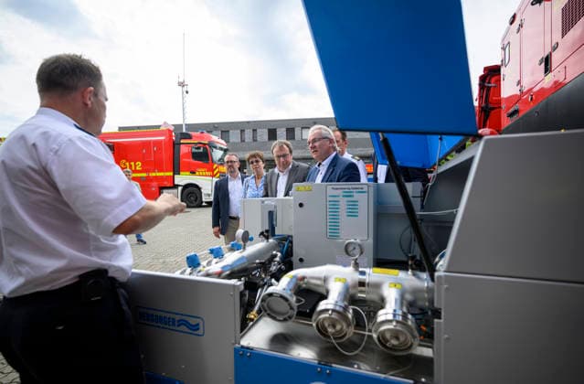 (l-r) David Lüngen (Stadtdirektor der Stadt Mülheim), Elke Reichert (Präsidentin des Landesamtes für Natur, Umwelt und Klima), Oliver Krischer (Minister für Umwelt, Naturschutz und Verkehr NRW), Marc Buchholz (Oberbürgermeister der Stadt Mülheim) bekommen die Mobile Anlage zur Trinkwasserversorgung in Notlagen von einem Feuerwehrmann erklärt. Pressetermin Umweltminister Oliver Krischer besucht das Krisenzentrum für Hochwasser in der Einsatzzentrale der Feuerwehr der Stadt Mülheim an der Ruhr, am 30.06.2026 in Mülheim Deutschland Ruhr Leitstelle der Feuerwehr Mülheim *** l r David Lüngen, City Manager of Mülheim; Elke Reichert, President of the State Office for Nature, Environment, and Climate; Oliver Krischer, Minister for the
