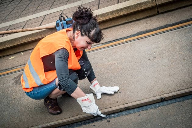 Leipziger Bürgerinnen und Bürger befreien am Johannisplatz gemeinsam mit den Leipziger Verkehrsbetrieben (LVB) die Straßenbahngleise von geschmolzenem Bitumen. Nachdem bereits am Vortag rund 100 Freiwillige einem Aufruf der LVB gefolgt waren, wurden die Reinigungsarbeiten am zweiten Tag am Johannisplatz fortgesetzt. Hintergrund sind die Schäden durch die extremen Temperaturen des vergangenen Hitzewochenendes. Aufnahme vom Datum . Reinigung Leipzig *** Residents of Leipzig are working together with the Leipzig Public Transportation Authority (LVB) to clear melted asphalt from the tram tracks at Johannisplatz. After about 100 volunteers had already responded to a call for help from the LVB the previous day, cleanup efforts continued on t