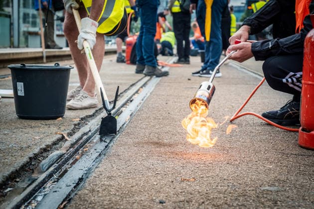 Leipziger Bürgerinnen und Bürger befreien am Johannisplatz gemeinsam mit den Leipziger Verkehrsbetrieben (LVB) die Straßenbahngleise von geschmolzenem Bitumen. Nachdem bereits am Vortag rund 100 Freiwillige einem Aufruf der LVB gefolgt waren, wurden die Reinigungsarbeiten am zweiten Tag am Johannisplatz fortgesetzt. Hintergrund sind die Schäden durch die extremen Temperaturen des vergangenen Hitzewochenendes. Aufnahme vom Datum . Reinigung Leipzig *** Residents of Leipzig, together with the Leipzig Public Transportation Authority (LVB), are clearing melted asphalt from the tram tracks at Johannisplatz. After about 100 volunteers had already responded to a call for help from the LVB the previous day, cleanup efforts continued on the sec