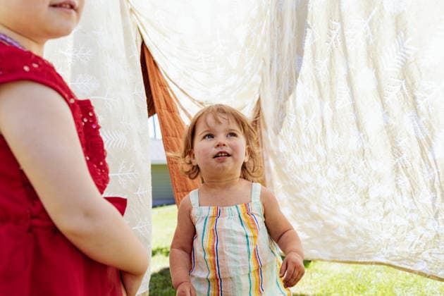 Child looking in wonder at blanket fort on laundry line Painesdale, Michigan, United States R_OAXI260629A-1995935-01 ,model released, Symbolfoto