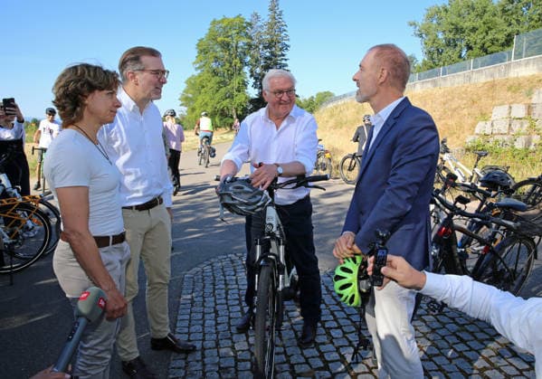 Bundespräsident Frank-Walter Steinmeier fährt in Begleitung des Lörracher Oberbürgermeisters Jörg Lutz (rechts) mit dem Fahrrad über die deutsch-schweizerische Grenze von Lörrach-Stetten nach Riehen. Am Grenzstein zur Schweiz trifft er die Gemeindepräsidentin von Riehen, Christine Kaufmann (links) sowie den basel-städtischen Regierungspräsidenten Conradin Cramer (2. v.l.). Bundespräsident Frank-Walter Steinmeier fährt in Begleitung des Lörracher Oberbürgermeisters Jörg Lutz (rechts) mit dem Fahrrad über die deutsch-schweizerische Grenze von Lörrach-Stetten nach Riehen. Am Grenzstein zur Schweiz trifft er die Gemeindepräsidentin von Riehen, Christine Kaufmann (links) sowie den basel-städtischen Regierungspräsidenten Conradin Cramer (2. v.l.)