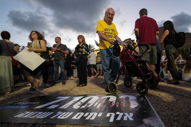 July 2, 2026, Tel Aviv, Israel: A protester stands next to a banner on the ground reading, 1,000 days of shiva. during an anti-government rally. A rally was held to mark 1,000 days since the October 7 massacre. Demonstrators protested against the Israeli government, accusing it of responsibility for the failures that led to the attack and calling for a state commission of inquiry, which they say the government opposes because its findings could implicate Prime Minister Benjamin Netanyahu. Tel Aviv Israel - ZUMAs197 20260702_aaa_s197_343 Copyright: xYaelxGuiskyxAbasx