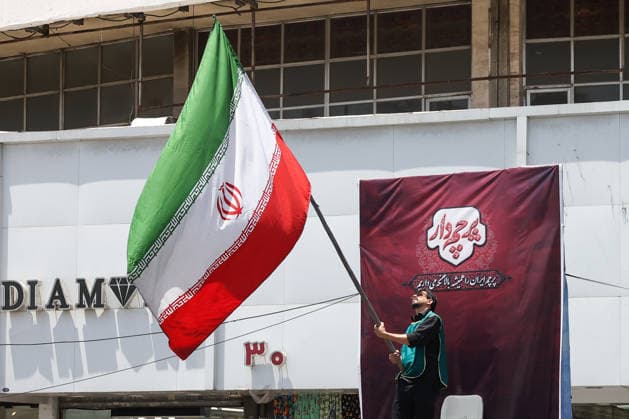 IRAN, TEHRAN - JULY 3, 2026: A man waves a national flag on the eve of the state funeral of Supreme Leader Ali Khamenei (1939-2026) set to take place from July 4 to 9. Khamenei was killed in a joint US-Israeli airstrike on his residence on February 28 Tehran Iran  - ZUMAt113 20260703_zaa_t113_119 Copyright: xValeryxSharifulinx