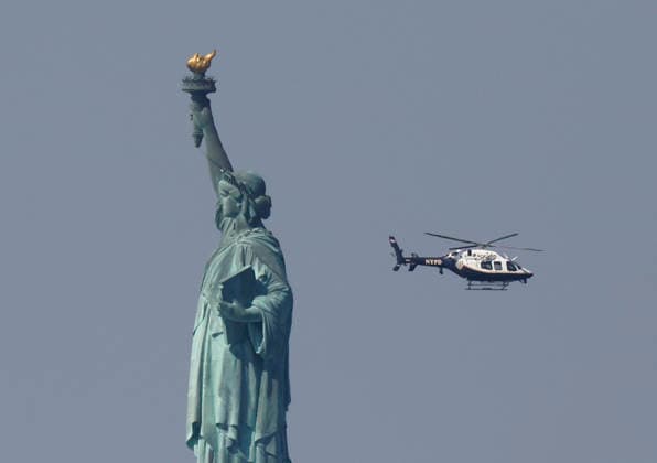 An NYPD Police helicopter passes by the Statue of Liberty one day before the July 4th holiday and the 250th anniversary of the United States on Friday July 3, 2026 in New York City.  NYP202607031905 JOHNxANGELILLO