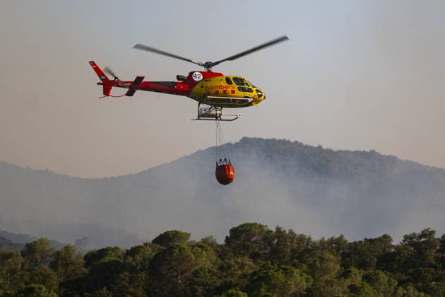 Spain battles major Costa Brava wildfire after 1,800 hectares burn LA BISBAL D’EMPORDA, SPAIN - JULY 03: A helicopter carries water to contain flames as a wildfire tears through the ecologically sensitive Les Gavarres mountain range in the Baix Emporda district of Catalonia, Spain, on July 3, 2026. A wildfire that broke out on Friday in the Baix Emporda district on Spain s Costa Brava has forced tens of thousands of people to remain indoors and has burned around 1,800 hectares, according to preliminary figures from regional authorities, as firefighters continue efforts to bring the blaze under control. Fanned by strong tramontana winds, the fire is affecting mainly the Les Gavarres mountain range, an area of high ecological value. Catalonia  Copyright: x2026xAnadoluxLorenaxSopenaxLopezx
