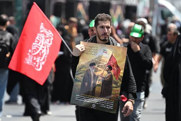 Iran Late Supreme Leader Funeral Rites 9199580 04.07.2026 A man holds a flag and a poster, depicting late Iran s Supreme Leader Ayatollah Ali Khamenei, on a street in Tehran, Iran. Iran s ruling clerics are preparing days of mass funeral events for late Supreme Leader Ayatollah Ali Khamenei killed in U.S. and Israeli strikes on Iran during the conflict in late February. Ilya Pitalev Sputnik Tehran Iran  Copyright: xIlyaxPitalevx