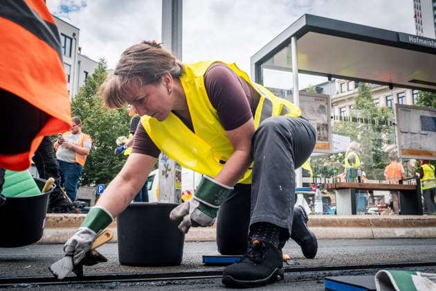 Freiwillige Helfer reinigen gemeinsam mit Mitarbeitenden der Leipziger Verkehrsbetriebe (LVB) Straßenbahngleise an der Leibnizstraße in Leipzig (Sachsen) von geschmolzenem Bitumen. Die Arbeiten sind Teil eines dritten Subbotniks zur Beseitigung der Hitzeschäden am Straßenbahnnetz. Aufnahme vom 4. Juli 2026. Hilfsaktion Leipzig *** Volunteers are working alongside employees of the Leipzig Public Transportation Authority (LVB) to clean melted bitumen from the tram tracks on Leibnizstraße in Leipzig, Saxony. The work is part of a third subbotnik aimed at repairing heat damage to the tram network. Photo taken on July 4, 2026. VolunteerLeipzig Relief Effort