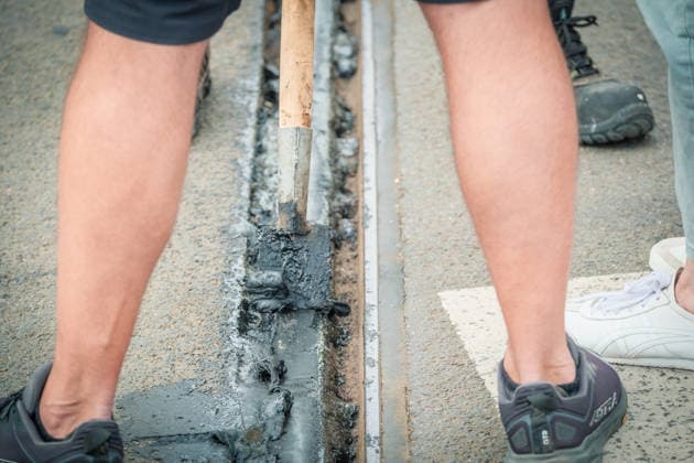 Freiwillige Helfer reinigen gemeinsam mit Mitarbeitenden der Leipziger Verkehrsbetriebe (LVB) Straßenbahngleise an der Leibnizstraße in Leipzig (Sachsen) von geschmolzenem Bitumen. Die Arbeiten sind Teil eines dritten Subbotniks zur Beseitigung der Hitzeschäden am Straßenbahnnetz. Aufnahme vom 4. Juli 2026. Hilfsaktion Leipzig *** Volunteers are working alongside employees of the Leipzig Public Transportation Authority (LVB) to clean melted bitumen from the tram tracks on Leibnizstraße in Leipzig, Saxony. The work is part of a third subbotnik aimed at repairing heat damage to the tram network. Photo taken on July 4, 2026. VolunteerLeipzig Relief Effort