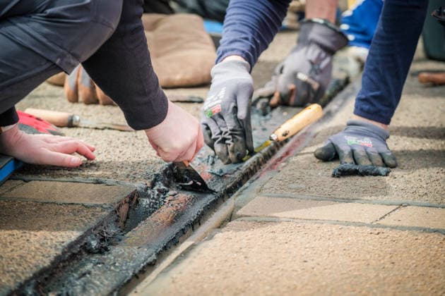 Freiwillige Helfer reinigen gemeinsam mit Mitarbeitenden der Leipziger Verkehrsbetriebe (LVB) Straßenbahngleise an der Leibnizstraße in Leipzig (Sachsen) von geschmolzenem Bitumen. Die Arbeiten sind Teil eines dritten Subbotniks zur Beseitigung der Hitzeschäden am Straßenbahnnetz. Aufnahme vom 4. Juli 2026. Hilfsaktion Leipzig *** Volunteers are working alongside employees of the Leipzig Public Transportation Authority (LVB) to clean melted bitumen from the tram tracks on Leibnizstraße in Leipzig, Saxony. The work is part of a third subbotnik aimed at repairing heat damage to the tram network. Photo taken on July 4, 2026. VolunteerLeipzig Relief Effort