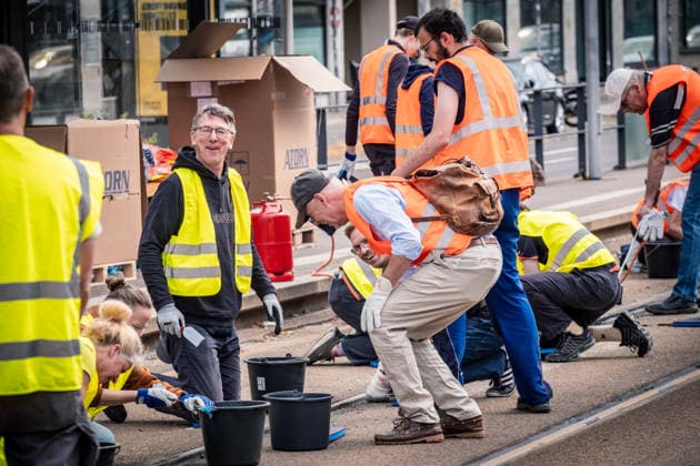 Freiwillige Helfer reinigen gemeinsam mit Mitarbeitenden der Leipziger Verkehrsbetriebe (LVB) Straßenbahngleise an der Leibnizstraße in Leipzig (Sachsen) von geschmolzenem Bitumen. Die Arbeiten sind Teil eines dritten Subbotniks zur Beseitigung der Hitzeschäden am Straßenbahnnetz. Aufnahme vom 4. Juli 2026. Hilfsaktion Leipzig *** Volunteers are working alongside employees of the Leipzig Public Transportation Authority (LVB) to clean melted bitumen from the tram tracks on Leibnizstraße in Leipzig, Saxony. The work is part of a third subbotnik aimed at repairing heat damage to the tram network. Photo taken on July 4, 2026. VolunteerLeipzig Relief Effort