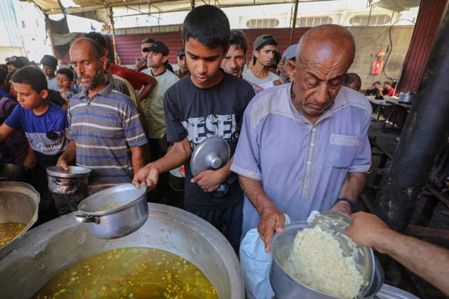 Hot meals distributed to Palestinians in Gaza under Israeli attacks NUSEIRAT, GAZA, PALESTINE - JULY 4: Palestinians, including children, gather to receive hot meals at a food distribution point in the Nuseirat refugee camp in central Gaza on July 4, 2026. Food shortages continue across the Gaza Strip as Israeli blockade and restrictions on the entry of humanitarian aid persist. Hassan Jedi Anadolu Nuseirat Gaza. Editorial use only. Please get in touch for any other usage.  Copyright: x2026xAnadoluxHassanxJedix