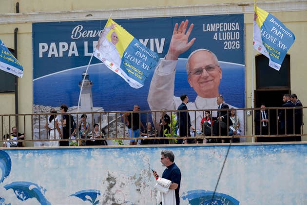 Pope Leo XIV visits the Southern Italian island of Lampedusa LAMPEDUSA, ITALY - JULY 04: People seen near a photo of Pope Leo XIV at the municipal palace in Lampedusa, Italy, on July 04, 2026. Pope Leo XIV arrived in Lampedusa to rise attention to the migrant issue and the unique position of the island. During his visit he met with a group of migrants, accompanied by the Red Cross at Favaloro Pier, inaugurating a new plaque with the new name of the Pier dedicated to Pope Francis. Later nearly 4000 people gathered in the sport field to attend the homily celebrated by the Pope. Valeria Ferraro Anadolu Lampedusa Italy. Editorial use only. Please get in touch for any other usage.  Copyright: x2026xAnadoluxValeriaxFerrarox