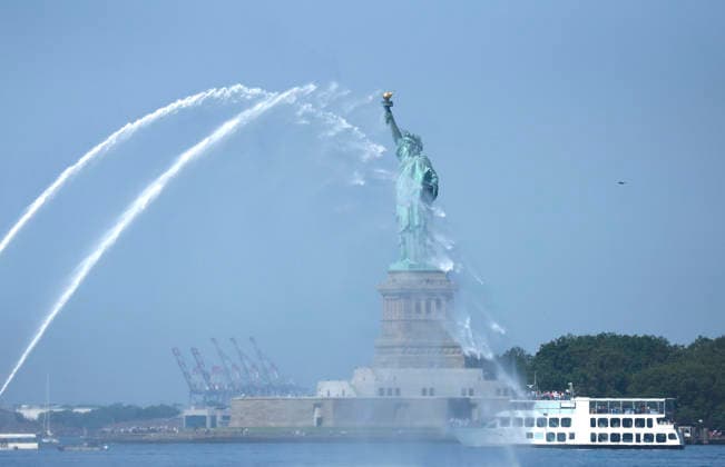 New York City Fire Department boats spray water in the air near he Statue of Liberty as part of Sail4th 250, a celebration for America s 250th anniversary, in New York City on Saturday, July 4, 2026. The event includes over 100 tall ships and navy vessels from more than 30 nations.  NYP20260704235 JOHNxANGELILLO