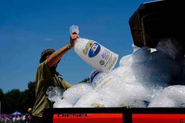 A vendor unloads sacks of ice at the Great American State Fair on the National Mall as high temperatures disrupt some events during America s 250th anniversary in Washington DC on Saturday, July 4, 2026.  WAP20260704505 BONNIExCASH