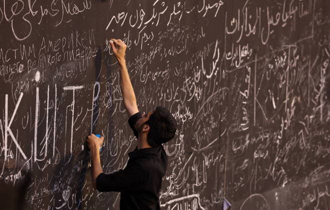 IRAN, TEHRAN - JULY 5, 2026: A man chalks his message outside the Grand Mosalla of Tehran (Imam Khomeini Mosalla of Tehran) during the state funeral of Iranian Supreme Leader Ayatollah Ali Khamenei (1939-2026). Khamenei was killed in a joint US-Israeli airstrike on February 28. Valery Sharifulin TASS  94665601