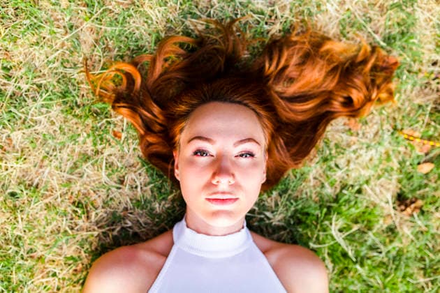 Portrait of redheaded woman lying on a meadow model released, Symbolfoto, GIOF04202