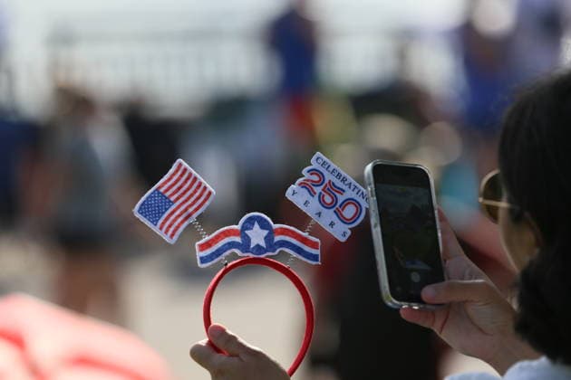 (260705) -- NEW YORK, July 5, 2026 -- A spectator holds a decoration during a parade of sail and a flyover celebrating America s 250th anniversary of founding in Jersey city of New Jersey, the United States, on July 4, 2026. ) U.S.-250TH ANNIVERSARY-INDEPENDENCE-CELEBRATIONS ZhangxFengguo 