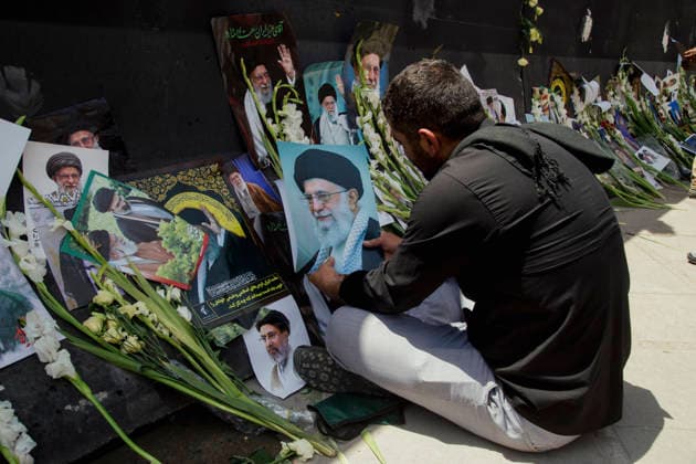 Tehran Iran Khamenei Funeral July 4 A mourner looks at portraits of Iranian leaders and flowers placed at a makeshift memorial during the funeral ceremony for Iran s late Supreme Leader Ayatollah Ali Khamenei in the courtyard of the Imam Khomeini Grand Mosalla in Tehran, Iran, on July 4, 2026. Ayatollah Khamenei and members of his family were killed on February 28 in a U.S.-Israeli airstrike during the first day of a military campaign against the Islamic Republic. The attack brought an end to his 36-year rule, leading to a six-day multi-city state funeral and drawing thousands of mourners to pay their final respects. Tehran Tehran Iran Copyright: xHosseinxBerisx