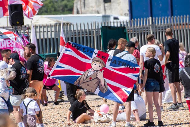 Far-right demo and antifascist counter-protest in Dover, UK - 04 Jul 2026 A child holds a flag during a demonstration outside the Immigration Centre in Dover. Around 100-120 supporters of the Pink Ladies gathered from across the country in Dover, UK. The Pink Ladies is an anti immigration far-right movement. The far-right activists marched through central Dover to the Immigration Centre and they were confronted by a small group of antifascist counter-protesters during their march. Dover United Kingdom Copyright: xKrisztianxElekx xSOPAxImagesx SSS_20260704_FAR_RIGHT_0011005015