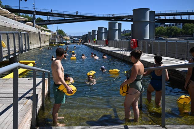 (260705) -- PARIS, July 5, 2026 -- People swim in the Seine River, Paris, France, on July 4, 2026. Paris opened some swimming sites in the Seine River to help people escape heat on Saturday. (Photo by Xinhua) FRANCE-PARIS-SEINE RIVER-SWIMMING-OPEN EmmaxDaxSilva 