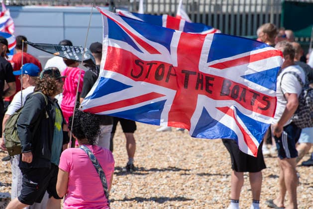 July 4, 2026, Dover, United Kingdom: A far-right activist holds a Union Jack flag during a demonstration outside the Immigration Centre in Dover. Around 100-120 supporters of the Pink Ladies gathered from across the country in Dover, UK. The Pink Ladies is an anti immigration far-right movement. The far-right activists marched through central Dover to the Immigration Centre and they were confronted by a small group of antifascist counter-protesters during their march. Dover United Kingdom  - ZUMAs197 20260704_aaa_s197_220 Copyright: xKrisztianxElekx