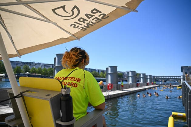(260705) -- PARIS, July 5, 2026 -- A lifeguard stands on duty along the Seine River in Paris, France, on July 4, 2026. Paris opened some swimming sites in the Seine River to help people escape heat on Saturday. (Photo by Xinhua) FRANCE-PARIS-SEINE RIVER-SWIMMING-OPEN EmmaxDaxSilva 