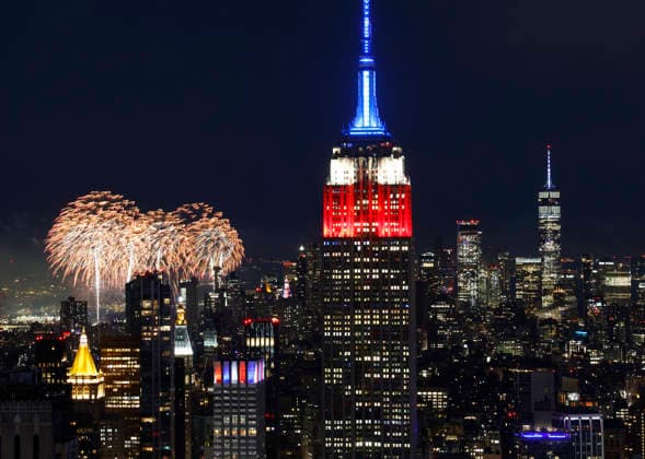 The Empire State Building is lit in red, white and blue as the Macy s 4th of July fireworks light up the night sky as part of the celebration of America s 250th anniversary as seen From the Top of the Rock Observation Deck at Rockefeller Center in New York City on Saturday, July 4, 2026.  NYP202607045006 JOHNxANGELILLO