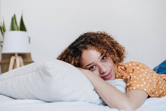 Young woman lying on bed at home model released, Symbolfoto property released, EBBF03838