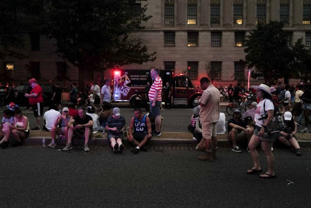 July 4, 2026, Washington, District Of Columbia, USA: Crowds sit and wait on a street median in Washington, D.C. on July 4, 2026, after the Freedom 250 Independence Day celebration on the National Mall was evacuated and portions of the event delayed to to incoming thunderstorms. Washington USA  - ZUMAd227 20260704_znp_d227_014 Copyright: xBryanxDozierx