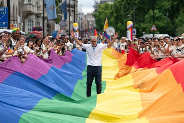 July 4, 2026, London, United Kingdom: London Mayor Sadiq Khan stands on LGBTQ+ flag during the parade. Participants take part in the annual Pride in London parade through central London, celebrating LGBTQ+ communities and advocating for visibility, unity and equality. Thousands of marchers, community groups, charities, businesses and campaign organisations join the procession, which travels through the capital with colourful costumes, banners, music and performances. Participants take part in the annual Pride in London parade through central London, celebrating LGBTQ+ communities and advocating for visibility, unity and equality. Thousands of marchers, community groups, charities, businesses and campaign organisations join the procession, w - ZUMAs197 20260704_aaa_s197_288 Copyright: xAndreaxDomeniconix