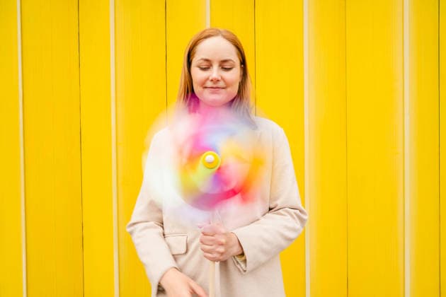 Businesswoman holding spinning pinwheel outdoors with optimism model released, Symbolfoto, IGEF01023