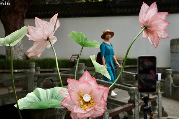 HANGZHOU, CHINA - JULY 04: A visitor walks among lotus art installations during a lotus market at the Confucius Temple on July 4, 2026 in Hangzhou, Zhejiang Province of China.  Copyright: xChinaxNewsxServicex 111652187684