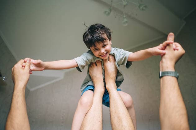 Father balances smiling boy on his feet indoors model released, Symbolfoto property released, ANAF06236