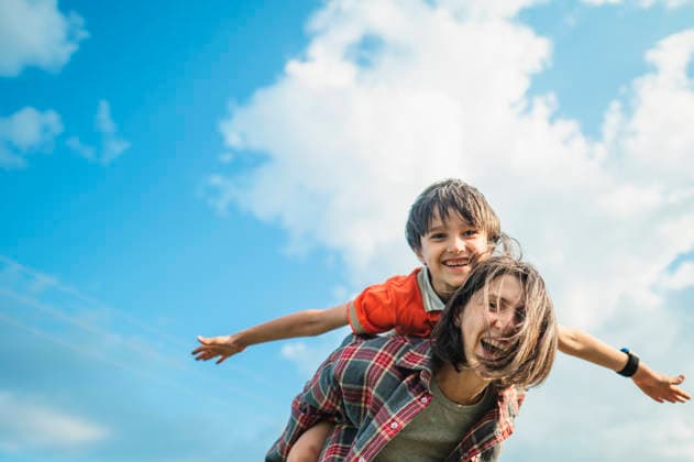 Happy mother gives her son a piggyback ride outdoors in summer model released, Symbolfoto, ANAF06258