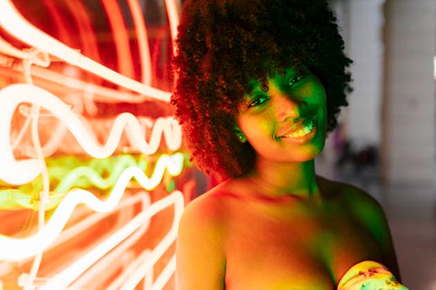 Afro young woman smiling by neon lights model released, Symbolfoto, JRVF01139