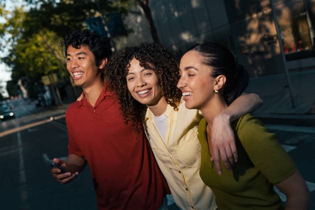 Happy friends walk together on a city street holding a smartphone model released, Symbolfoto, JSRF04535